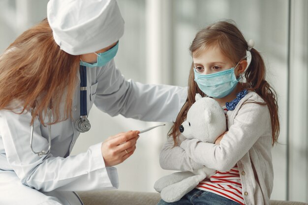 Doctor and a child in protective masks are in hospital