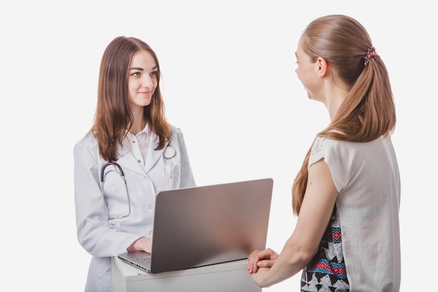 Doctor consulting woman at laptop