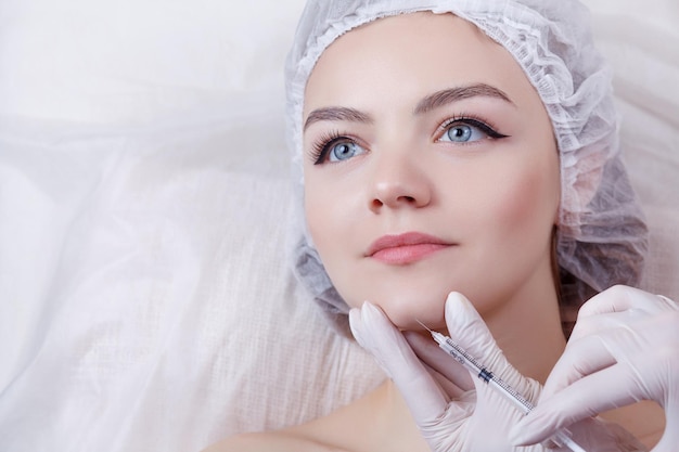 The doctor cosmetologist makes the rejuvenating facial injections procedure