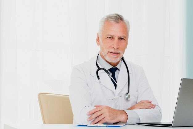 Doctor at desk looking at camera