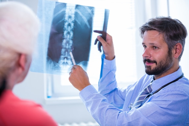 Доктор обсуждения рентгеновского излучения с пациентом