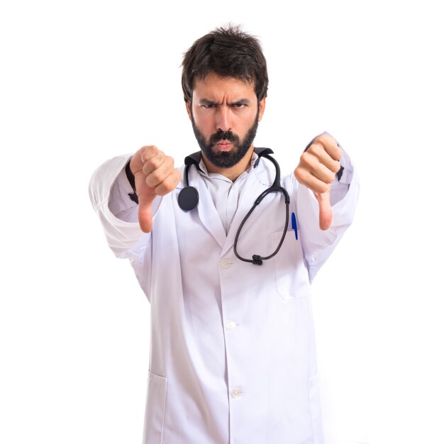 Doctor doing a bad signal over white background