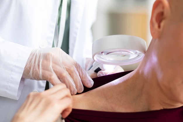 Free photo doctor doing a check on a patient with skin cancer