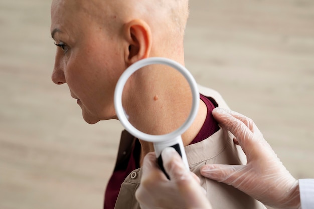 Foto gratuita dottore che fa un controllo su un paziente con cancro della pelle