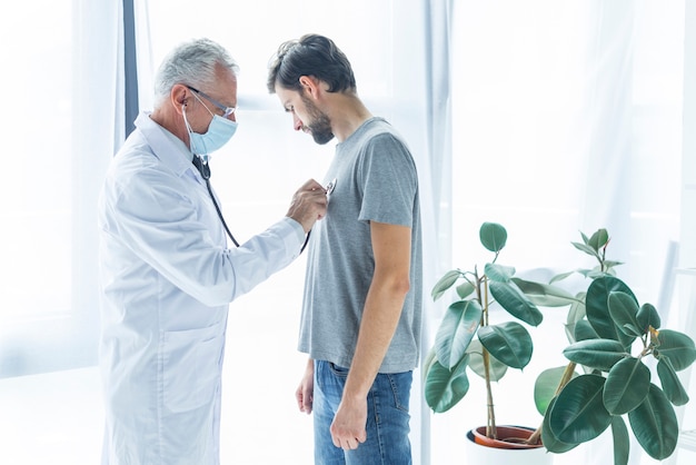 Doctor examining chest of patient