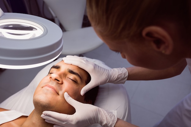 Doctor examining man face for cosmetic treatment