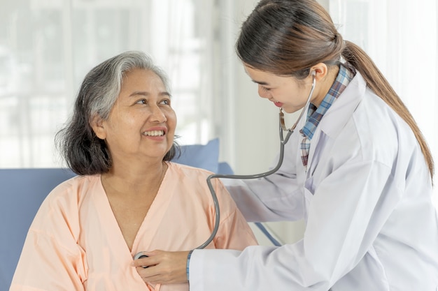 Doctor Examining senior elderly  Female Patient In Hospital bed patients - medical and healthcare senior concept