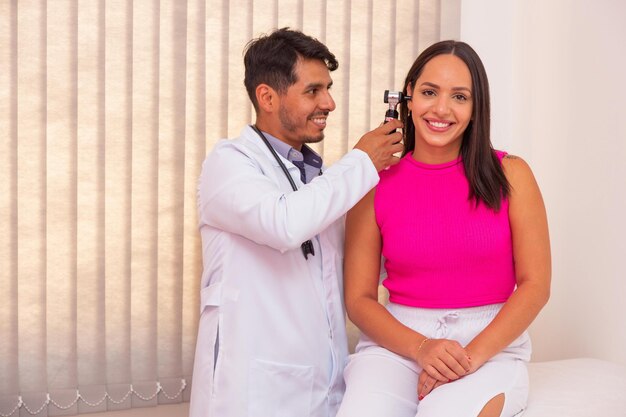 Doctor examining young woman's ear