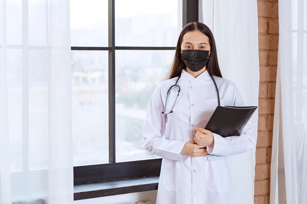 Doctor in eyeglasses raising hand for attention. 