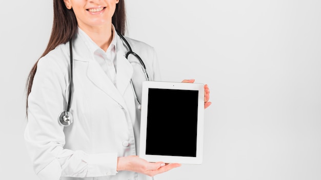 Doctor female smiling and holding tablet 