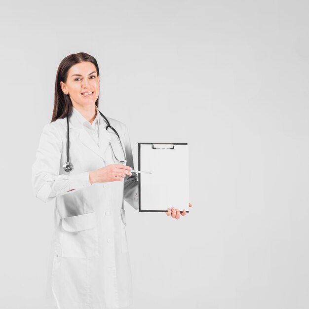 Doctor female smiling and showing on clipboard