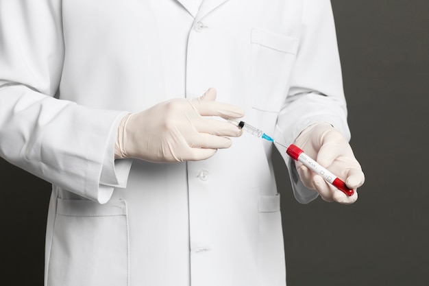 Doctor filling syringe with vaccine from vacutainer