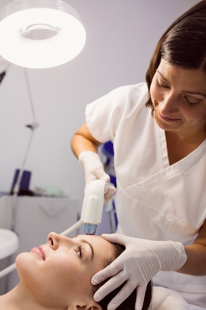 Doctor giving cosmetic treatment to female patient