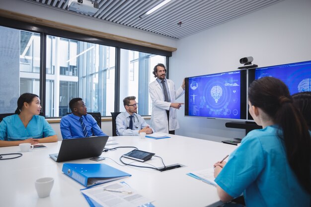 Free photo doctor giving presentation to team of interim doctors