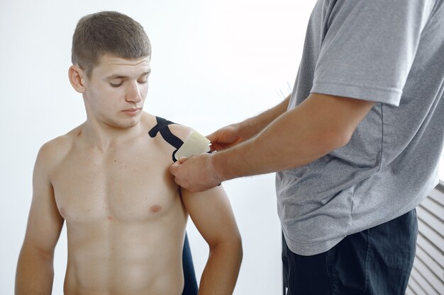 Doctor glues a tepee to an athlete at the hospital