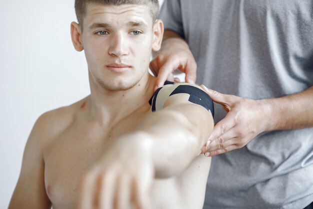 Doctor glues a tepee to an athlete at the hospital