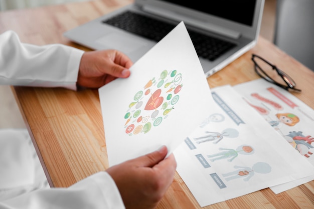 Free photo doctor hands holding a colorful diagram