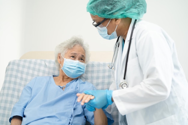 医師​は​、​安全​感染​を​保護し​、​covid​-​19​コロナ​ウイルス​を​殺す​ために​病院​で​フェイス​マスク​を​着用している​アジア​の​高齢者​または​高齢​の​老​婦人​女性​患者​を​助けます​。
