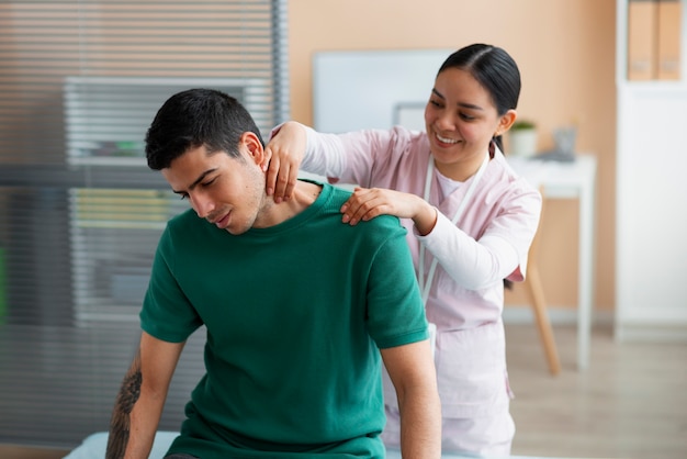 Foto gratuita medico che aiuta il paziente durante la riabilitazione