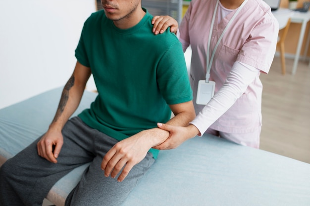 Doctor helping patient during rehabilitation