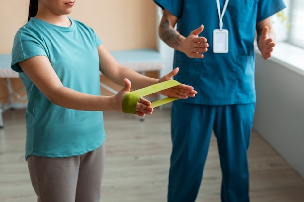 Doctor helping patient during rehabilitation