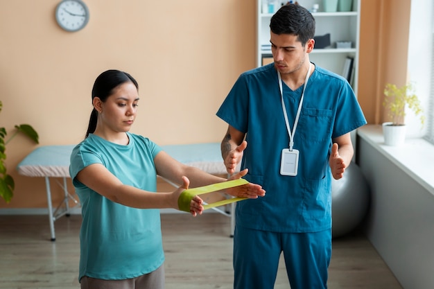 Doctor helping patient during rehabilitation