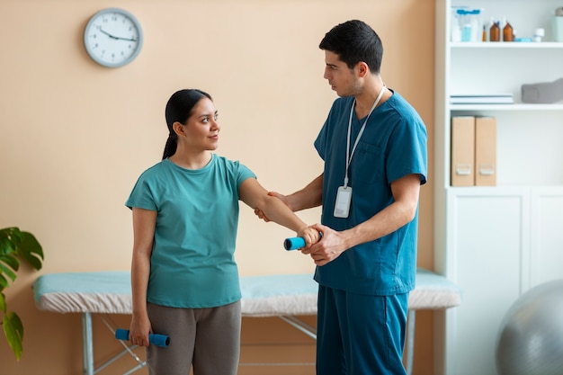 Doctor helping patient during rehabilitation