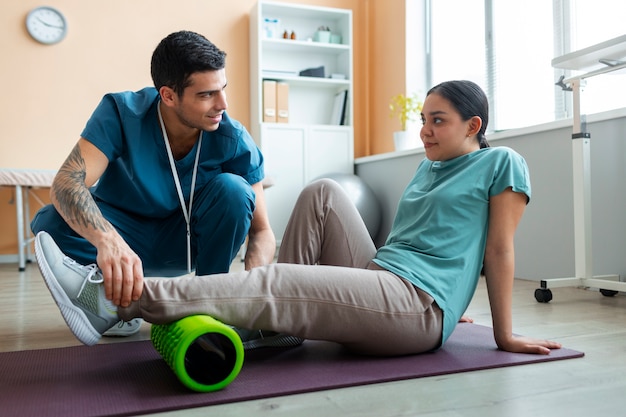 Doctor helping patient during rehabilitation