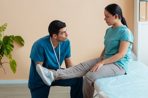 Doctor helping patient during rehabilitation