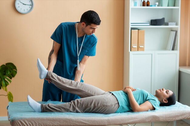 Doctor helping patient during rehabilitation