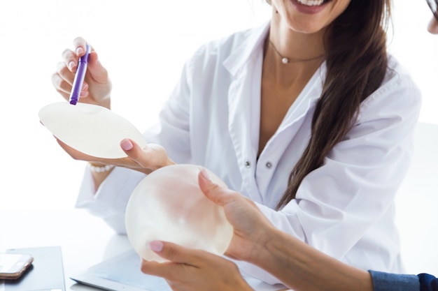 Doctor and her patient choosing mammary prosthesis in the office.