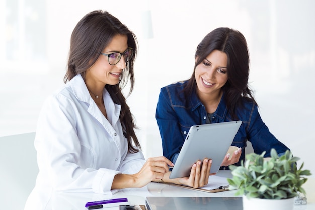 Doctor and her patient choosing mammary prosthesis in the office.