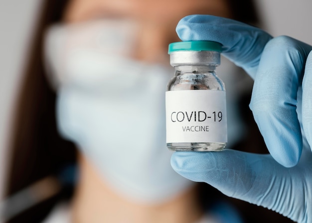 無料写真 covid-19ワクチンボトルを持っている医師