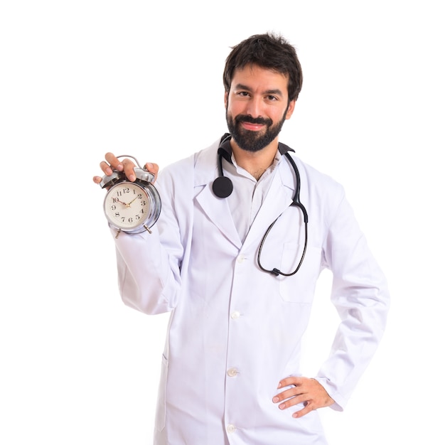 Doctor holding a clock over white background