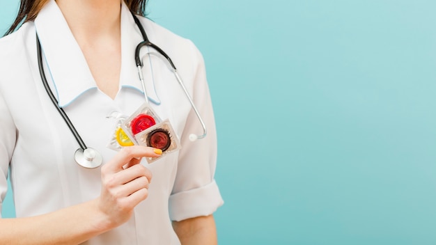 Free photo doctor holding condoms with copy space