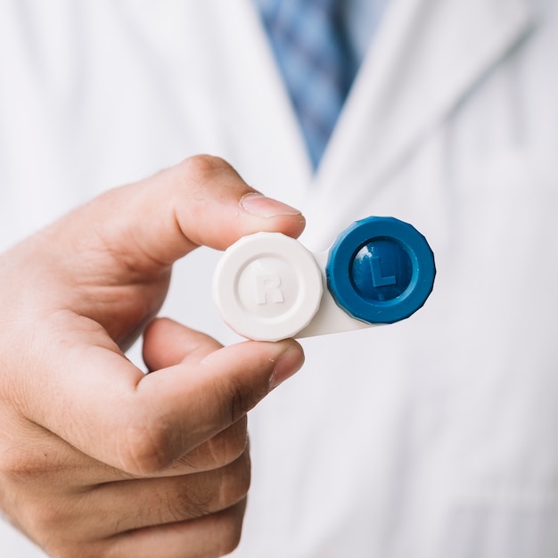 Free photo doctor holding a contact lenses case in his hand