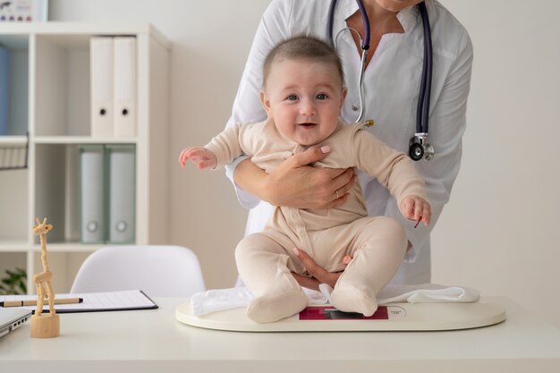 Doctor holding cute baby front view