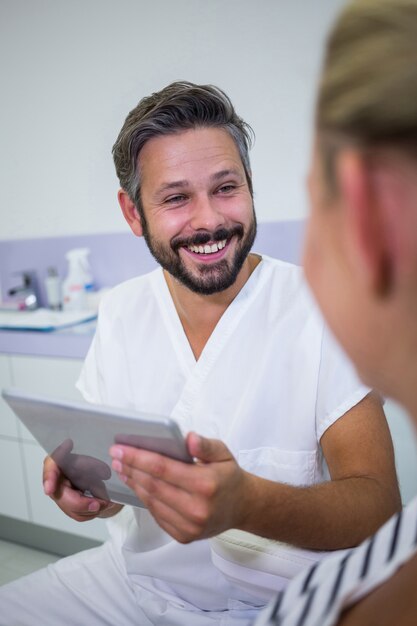 Foto gratuita aggiusti la tenuta della compressa digitale mentre parlano con il paziente