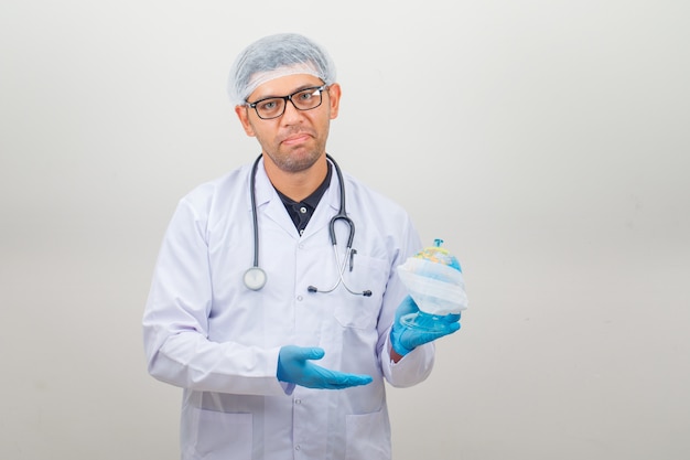 Doctor holding earth globe in white coat and hat ,