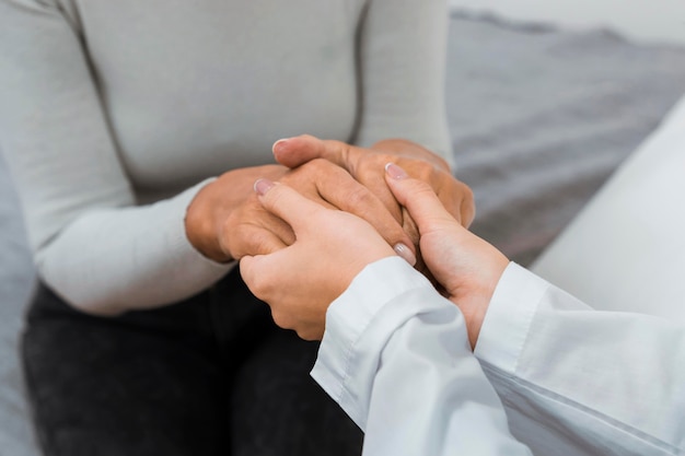 Doctor holding hands with patient