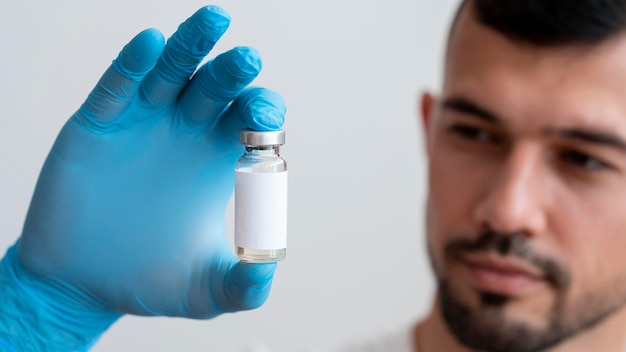 Free photo doctor holding medical vaccine