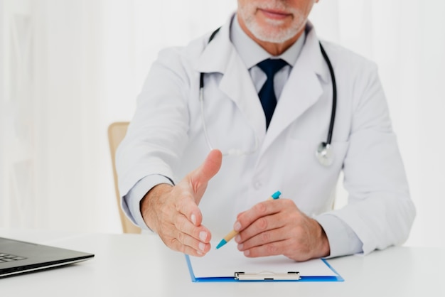 Doctor holding out his hand while sitting