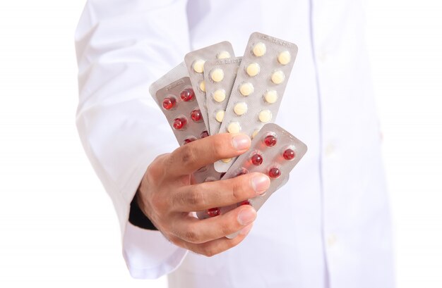 Doctor holding pills over white background