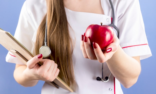 Доктор держит красное яблоко в руке