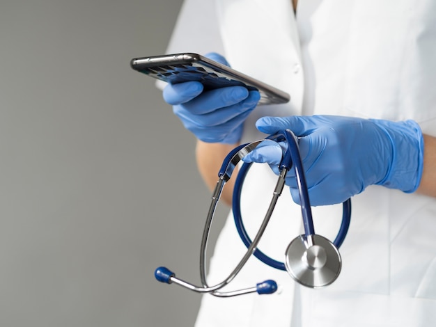 Doctor holding smartphone and stethoscope
