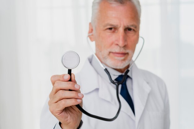 Doctor holding stethoscope defocused
