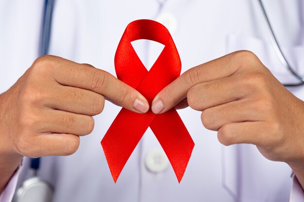 The doctor holds a red ribbon, HIV awareness awareness, World AIDS Day and World Sexual Health Day.