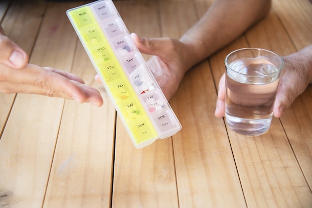 無料写真 医師は、患者がピルボックスで錠剤を正しく食べるのを支援します