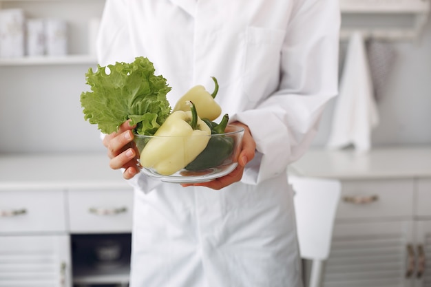 Medico in una cucina con verdure