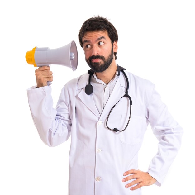 Doctor listening by megaphone over white background